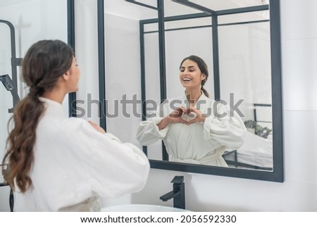 A picture of a young woman in a bathrobe in the bathroom