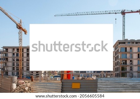 Advertising banner mock-up in front of the residential building under construction. Construction site on a sunny day.