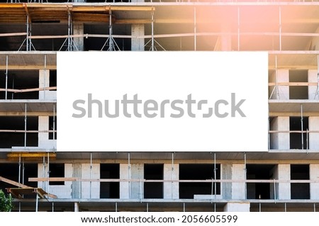 Blank white banner for advertisement on the facade of the building under construction