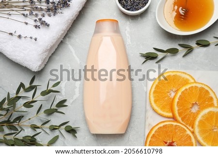 Flat lay composition with bottle of shower gel on light grey table