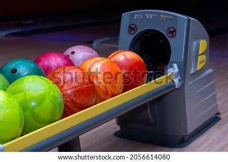 colorful bowling balls on a stand in a bowling club