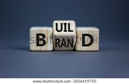 Build your brand symbol. Turned wooden cubes and changed the word 'build' to 'brand'. Beautiful grey background. Build your brand and business concept. Copy space. Royalty-Free Stock Photo #2056619750