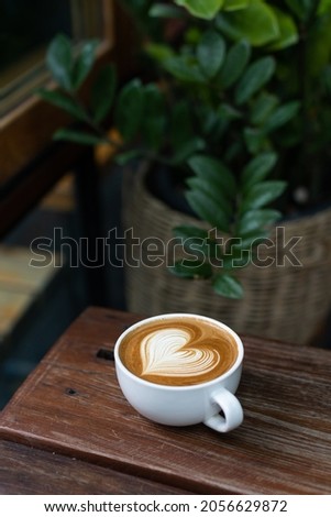 Heart latte art coffee on wood table background Royalty-Free Stock Photo #2056629872