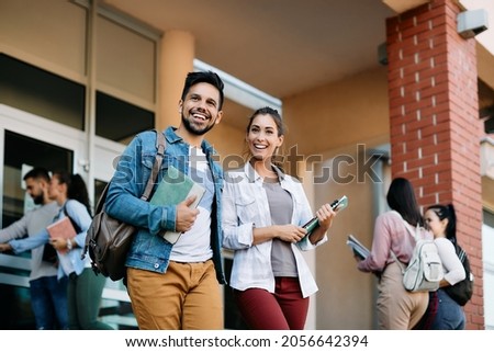 Happy university student and his female friend walking after the lecture at campus. Royalty-Free Stock Photo #2056642394
