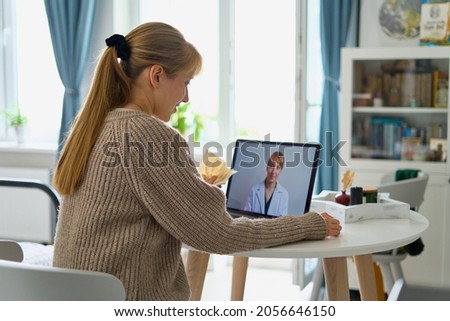 Woman calling doctor online. Telemedicine concept. Future tele consulting. Diagnostic from home. Video conference with therapist in kitchen. Sick female asking for help. E-medicine Royalty-Free Stock Photo #2056646150