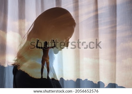 Brave strong woman standing on a mountain overcoming her mental fears. fighting self doubt, depression, sadness concept. double exposure Royalty-Free Stock Photo #2056652576