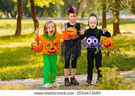 Kids trick or treat in Halloween costume. Happy Halloween. three running kids with a basket for sweets