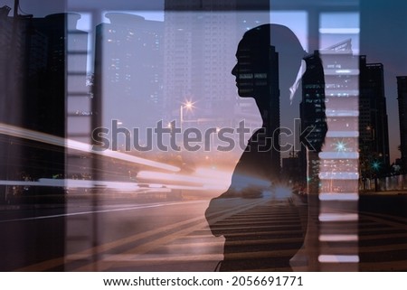 thoughtful woman looking at night city skyline