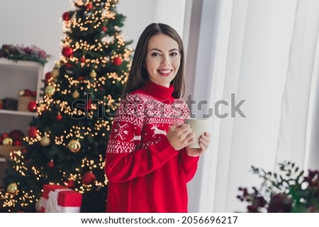Photo of young cheerful girl enjoy coffee hold mug decor evergreen tree holiday spirit jolly december indoors