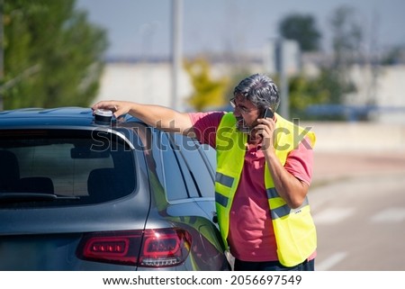 A man with his broken down vehicle signaling with an emergency light