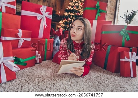 Photo of curious smart lady lay floor write wish-list think wear sweater in decorated x-mas home indoors