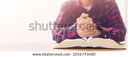Man praying on holy bible with wooden block word bible.Worship Faith and Read Bible Online at home.Bible study in home church, wisdom of GOD, Holy spirituality , Worship and Christian.Prayer pray.