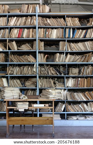 shelves full of files in a messy old-fashioned archive Royalty-Free Stock Photo #205676188