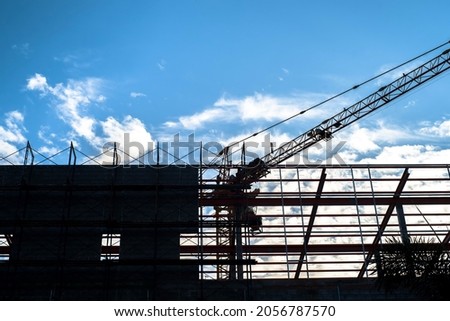 Silhouette of construction site with blue sky and white clouds