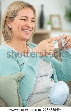 happy mature woman knitting smiling