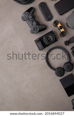 Overhead flat lay of black technology devices and gadgets on a grey background Royalty-Free Stock Photo #2056844027