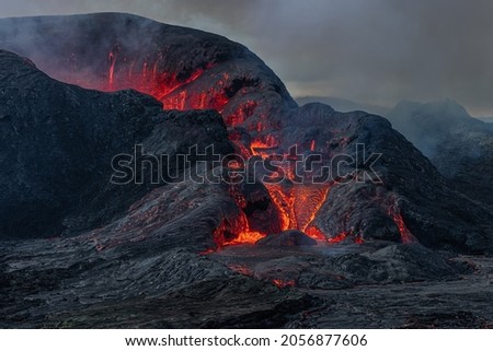 Side view of the crater opening from Fagradalsfjall volcano. Crater shortly after the lava flow on Iceland in the GeoPark. Clouds and steam in the sky. Daytime vulcanic eruption on Reykjanes peninsula Royalty-Free Stock Photo #2056877606