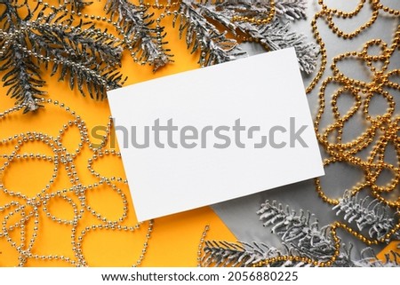 Christmas invitation card design. frame from fir branches and Christmas tree decorations on a yellow-gray background. white blank for the text. congratulation 
