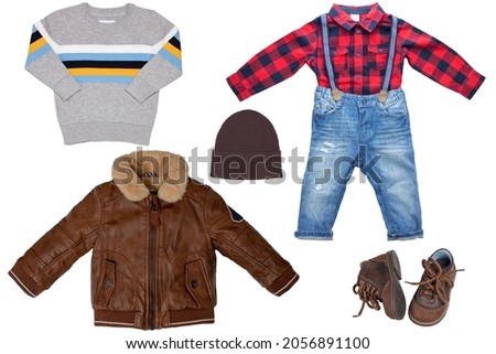 Collage set of little boy autumn clothing isolated on a white background. Denim trouser with plaid shirt, a pair shoes, a leather jacket and pullover or sweater for child boy. Kids winter fashion.