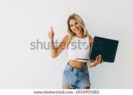 Young pretty woman use laptop computer and thumb up isolated on white background