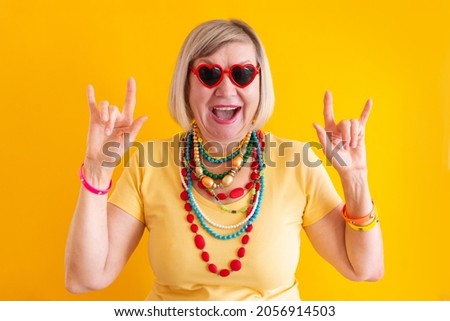 Happy mature elderly senior lady woman having fun in stylish clothes, concepts about senior people on colored background.