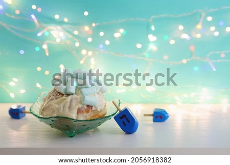 Image of jewish holiday Hanukkah with doughnut marshmallow and wooden dreidels (spinning top)