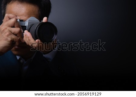 Close-up professional male photographer shooting indoor with vintage camera, empty area with copy space for your content, design or text message.