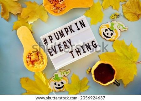 Text pumpkin everything, in high modern shadows, among autumn decorations and food. Orange teacup with homemade cookies, fresh pumpkins, yellow leaves and decorations of pumpkins. . High quality photo