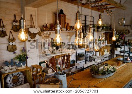 Beautiful arrangement of wooden decor and ceramic decoration in a shop for indoor, outdoor and garden. Light bulb as fairy lights.