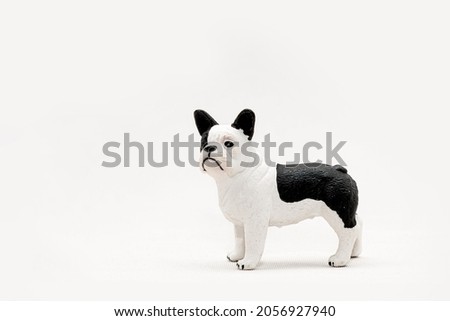 Plastic Toy Figures of Pets Isolated on White Background. Black and white dog, French bulldog