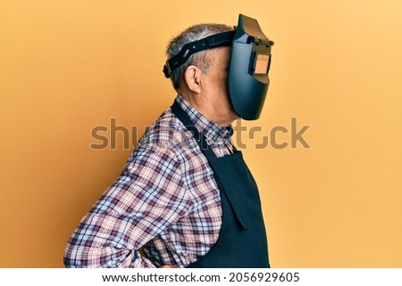 Repair man wearing professional welding mask over head covering face for protection