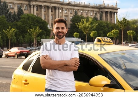 Handsome taxi driver near car on city street Royalty-Free Stock Photo #2056944953