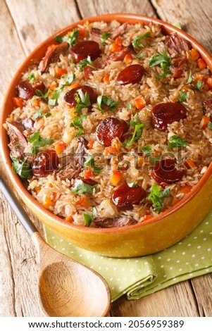 Arroz de Pato Portuguese Style Duck Rice with onion, carrot and chorizo close up in the baking dish on the wooden table. Vertical
 Royalty-Free Stock Photo #2056959389