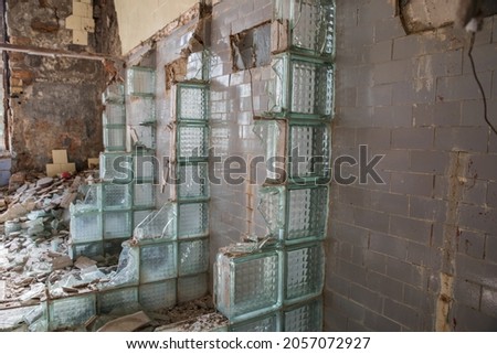 Broken windows in the ruins of a house.