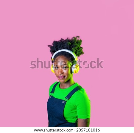 Portrait young black woman looking over listening music wireless headphones smiling happy and serene advertising copyspace background