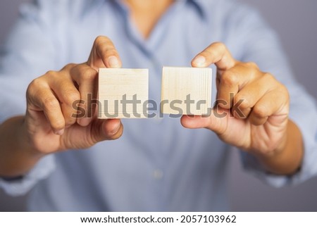 Two blank wooden cubes on hand. Mockup for text, icon, symbol, or logo creative and management concept. Close-up photo. Space for text.