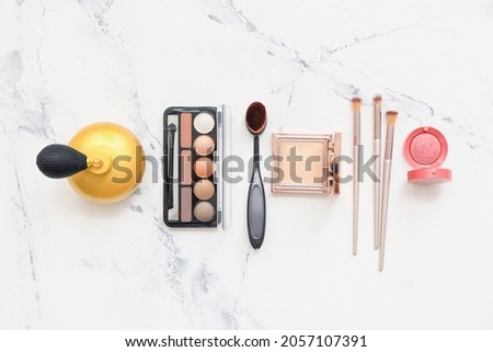 Set of makeup brushes with decorative cosmetics on white background