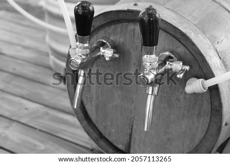 Craft beer dispensing taps on a wooden jockey barrel. This photo has selective focus. 