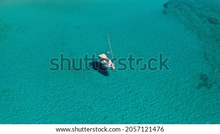Aerial drone photo of sail boat anchored in tropical turquoise and sapphire sea