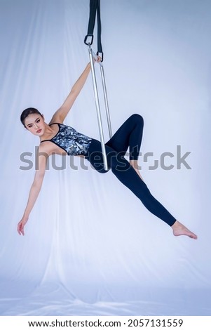 Portrait of an athlete in the air metal frame practice at studio, woman hanging in aerial square metal frame