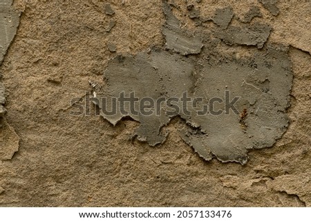 The wall is made of concrete and plaster. Textured plaster wall background, with a patch of concrete repair patch. Background and texture, for creating graphic and photo resources.