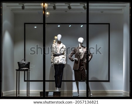 Shop windows and mannequins. Fashion Store exterior. City Night Boutique. Front View from street outdoor. LED light. City facade background Royalty-Free Stock Photo #2057136821