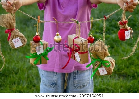 focus on the hands of a child holding a do-it-yourself avent calendar, seasonal activities for children, family winter holidays, selective focus