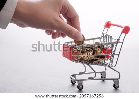 pile of coins in supermarket trolley, cashback concept, inflation on consumer goods, stock market investment, banking services, financial advisor Royalty-Free Stock Photo #2057167256
