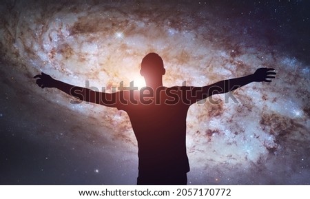 Silhouette of man on bright sky with stars and galaxies. Starry space background. Freedom and motivation. Meditation and astrology. Esoterica and psychology. Elements of this image furnished by NASA 