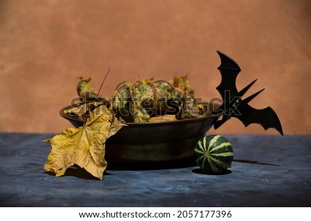 halloween and decoration concept- bat clothespin, pumpkin, maple leaves on textured background