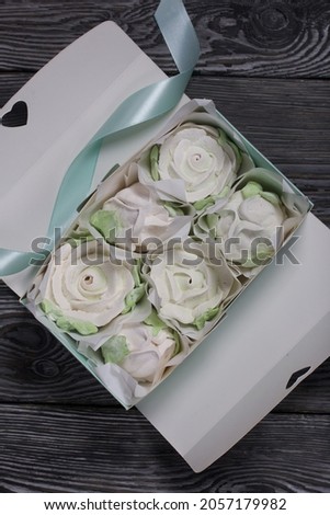 Homemade marshmallow in a gift box. Zephyr roses.  Marshmallow roses.  On black pine boards. Close-up shot.
