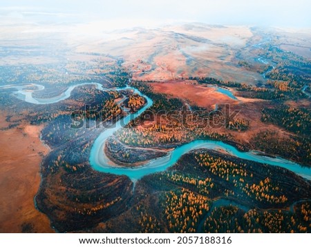 Chuya river in Kurai steppe, Altai mountains, Siberia, Russia. Aerial drone view. Blue river with yellow autumn trees with morning fog. Beautiful autumn landscape. Royalty-Free Stock Photo #2057188316