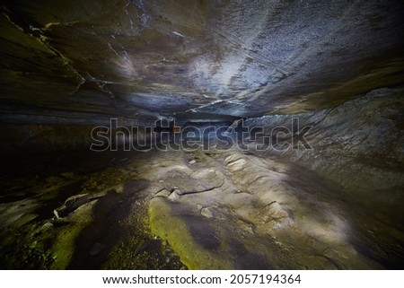 Wide cave that is short and has a smooth ceiling but a bumpy floor