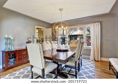 Elegant dining room interior with wooden table and ivory suede chairs